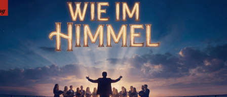 A musical poster with a group of people standing on a deck, singing under a sky filled with clouds and a bright light shining from above. The title 'Wie im Himmel' is displayed prominently in gold.