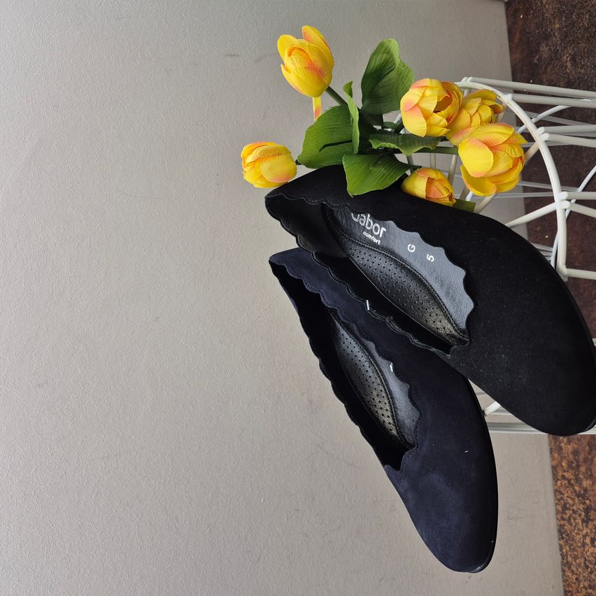 Schwarze Wildleder-Ballerinas von Labor Comfort mit gelben Tulpen obenauf.