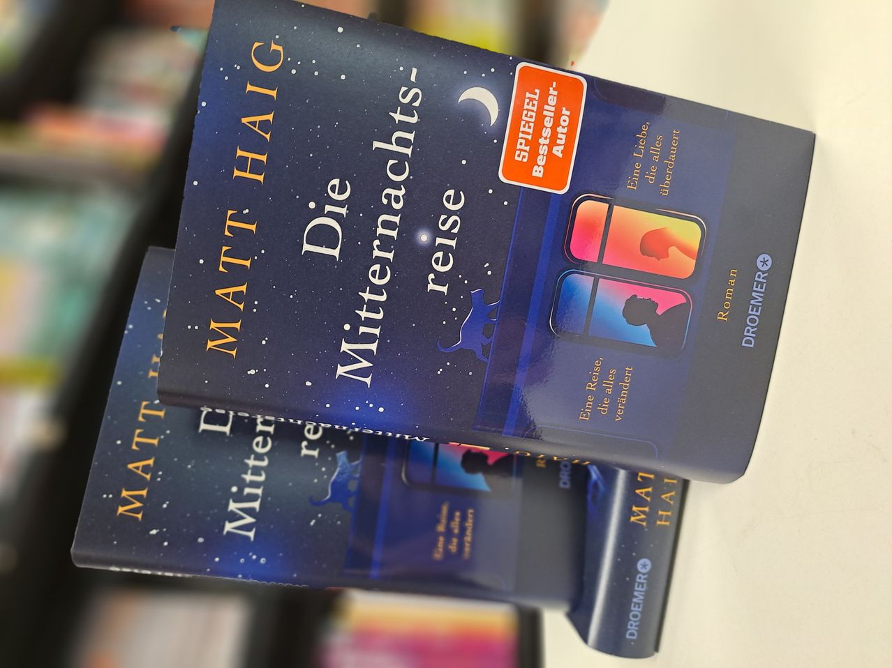 The book cover features a blue background with a starry night sky and a silhouette of a person. The title reads 'Die Mitternachtsreise' by Matt Haig, and there is a red sticker that says 'SPIEGEL Bestseller Autor'.