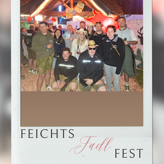 Eine Gruppe von Menschen, sowohl Männer als auch Frauen, posiert für ein Foto bei einer Zusammenkunft. Sie lächeln und einige tragen Hüte und Sonnenbrillen. Hinter ihnen befinden sich Dekorationen und eine Holzstruktur.