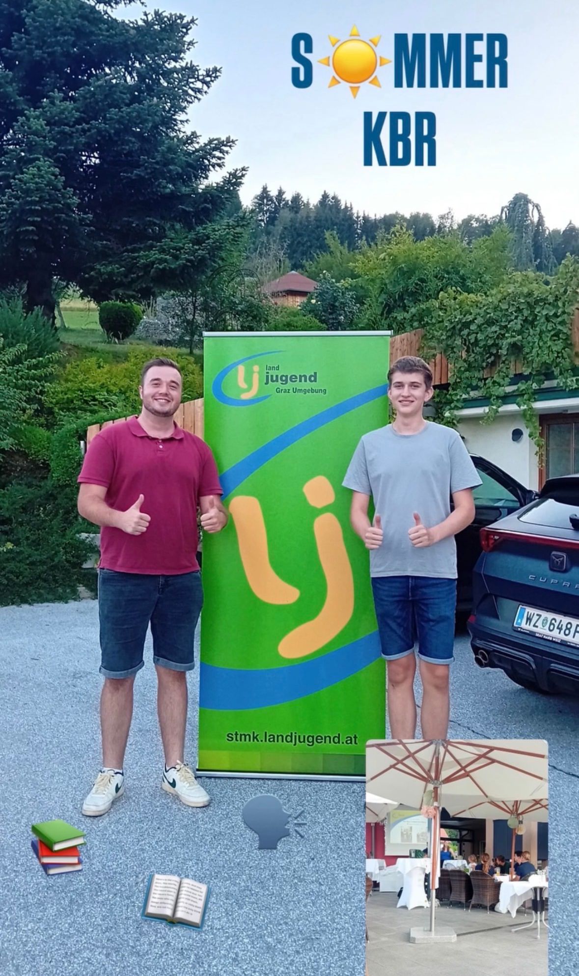 Zwei Männer stehen neben einem grünen Banner mit Logo und Text und geben Daumen hoch. Sie befinden sich auf einem Parkplatz mit einem Haus und Auto im Hintergrund.