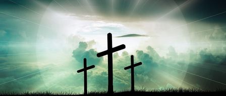 Three crosses stand against a backdrop of vibrant, stormy clouds and sunlight. The largest cross is in the center, flanked by two smaller ones.