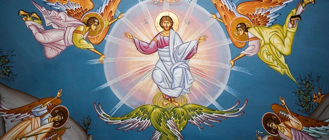 Eine religiöse Ikone zeigt Jesus, der auf einem grünen Blatt steht und von Engeln umgeben ist. Er hat die Arme ausgestreckt. Der Hintergrund ist eine Mischung aus Blau und Rosa.