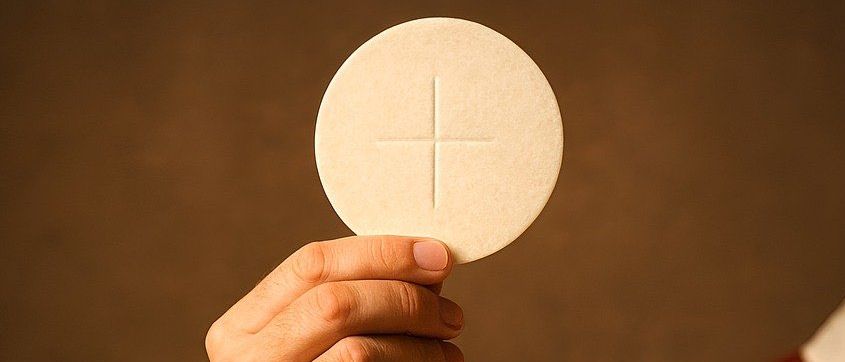 Ein Priester hält eine Kommunionhostie über einem goldenen Kelch während einer Zeremonie, symbolisiert die Eucharistie.