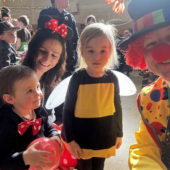 Eine Gruppe von Kindern und Erwachsenen in Kostümen, darunter eine Biene, ein Clown und Minnie Mouse, nehmen an einem Kinderfasching-Event am 4.3.2025 teil.