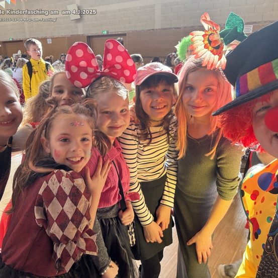 Gruppe von Kindern in Kostümen und mit Gesichtsbemalung posiert für ein Foto mit einem Clown bei einer Karnevalsveranstaltung am 4.3.2025.
