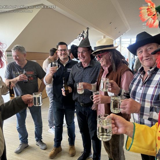 Eine Gruppe von Männern in Kostümen und Hüten, die Gläser mit Wasser halten, lächeln für ein Foto auf einer Party am 4. März 2025.