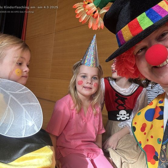 Eine Gruppe von Kindern in Kostümen für Kinderfasching, 4. März 2025. Ein Mädchen in einem rosa Kleid, ein Mädchen mit Partyhut und ein Clown mit roter Nase.
