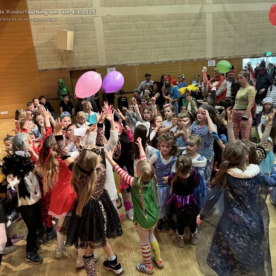 Eine Gruppe von Kindern in Kostümen ist drinnen versammelt, einige halten Luftballons, und sie scheinen ein Kinderfasching zu feiern. Das Datum 4.3.2025 ist oben sichtbar.
