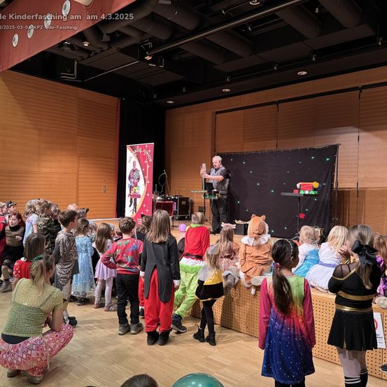 Ein Zauberer tritt auf der Bühne für eine Menge Kinder in Kostümen beim Kinderfasching-Event am 4. März 2025 auf.
