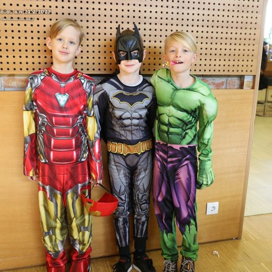 Drei Jungen, die als Iron Man, Batman und Hulk gekleidet sind, stehen für ein Foto am 21. Februar 2022 zusammen.