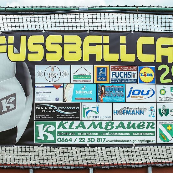 Ein Banner mit Fußballthema, das verschiedene Logos und Sponsoren zeigt. Es enthält den Text 'FUSSBALL CAFE 2'.