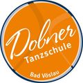 Orange rundes Logo für die Dobmer Tanzschule in Bad Vöslau, Österreich. Es zeigt den Namen Dobmer in weißer Schrift mit blauem Rand.