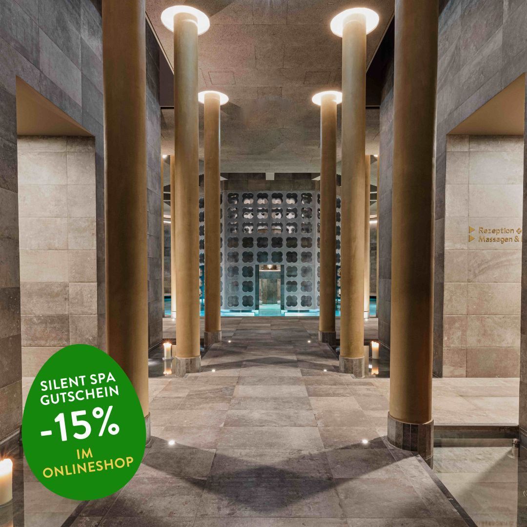 Innenansicht eines Spas mit Pool und gefliesten Böden, goldenen Säulen und einem Werbeaufkleber, der 'Silent Spa Gutschein -15% im Onlineshop' besagt.