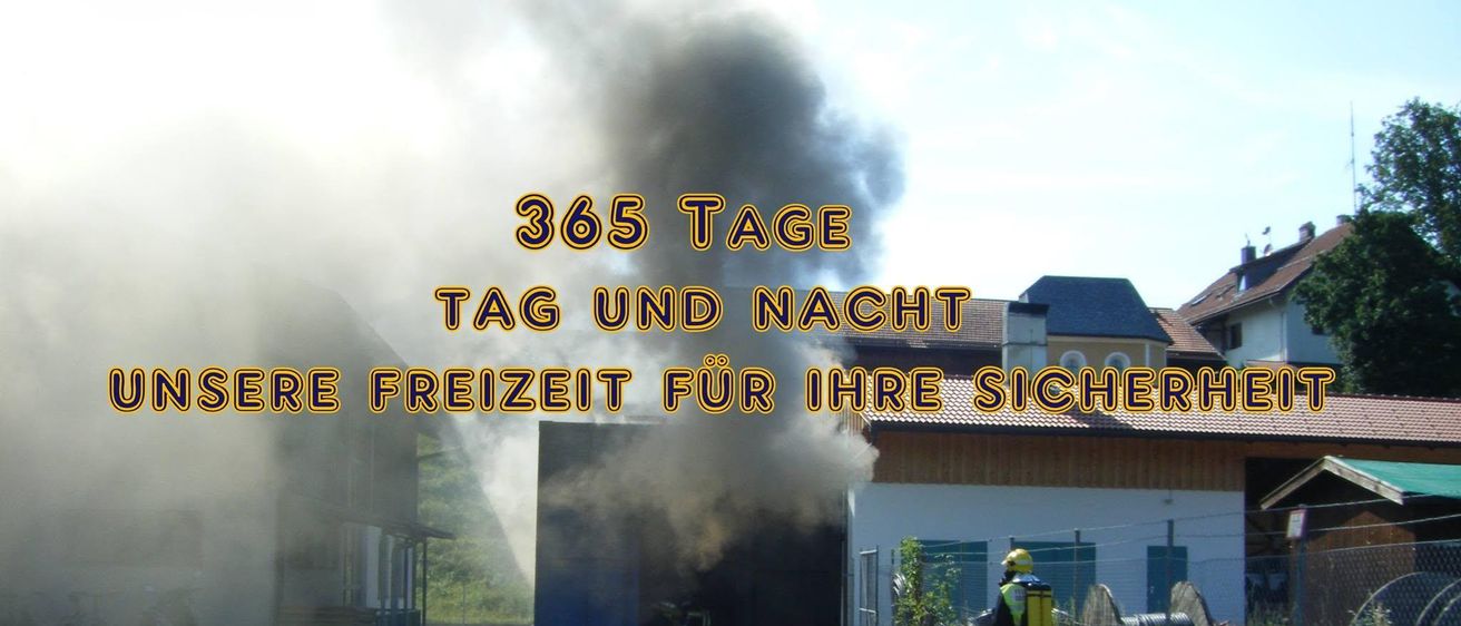 Feuerwehrleute bekämpfen einen brennenden Lastwagen, wobei Rauch die Luft erfüllt. Ein Haus und ein Zaun sind im Hintergrund zu sehen.