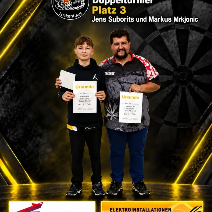 Zwei Männer stehen auf einer Bühne und halten Urkunden in den Händen. Einer ist ein junger Junge und der andere ein Erwachsener. Sie lächeln beide. Hinter ihnen befindet sich ein Dartboard und ein gelbes Licht.