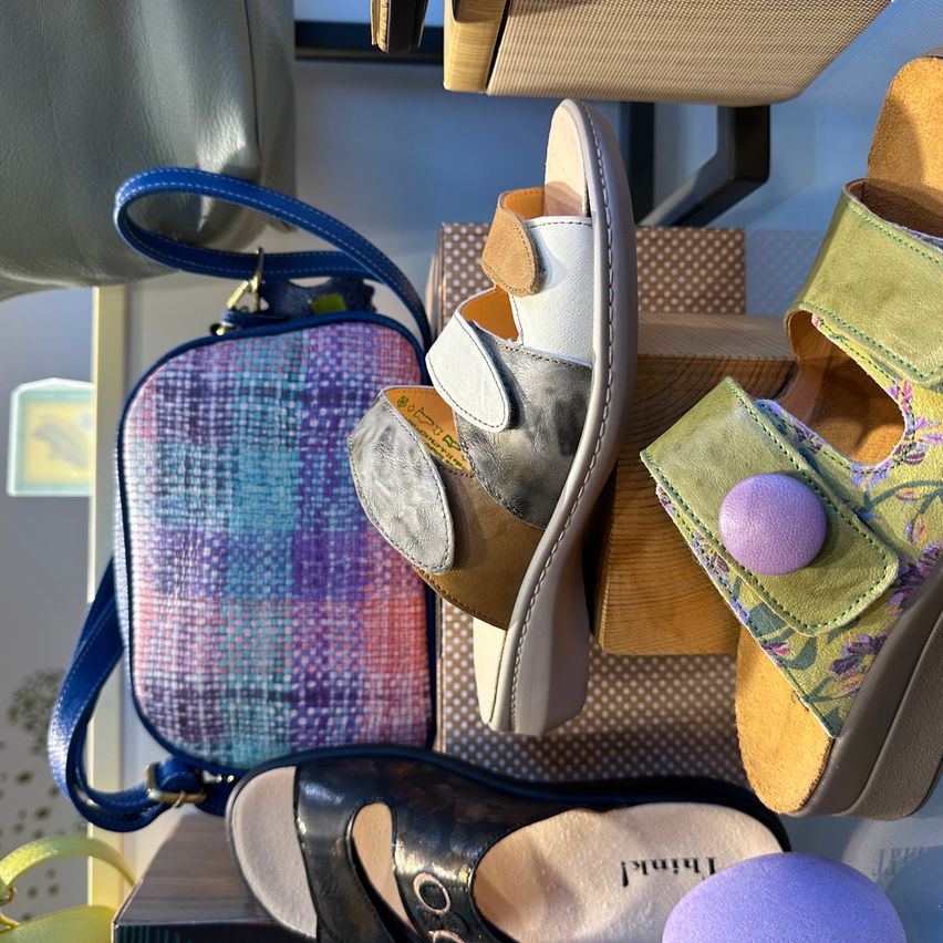 A display of fashionable sandals and bags in various colors and materials, with a focus on comfort and style.