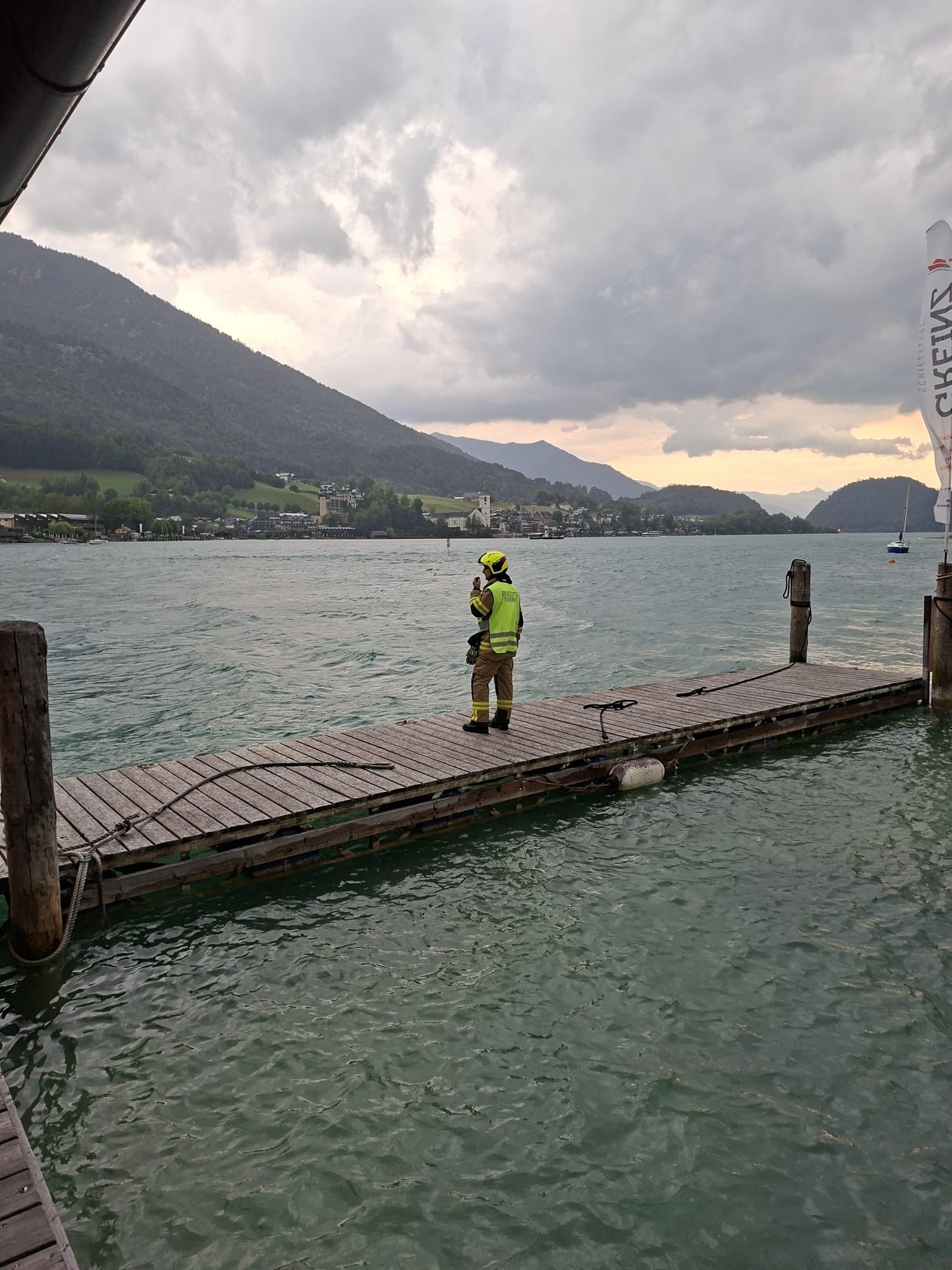 Feuerwehrmann am Steg in St. Wolfgang am Wolfgangsee mit Bergkulisse