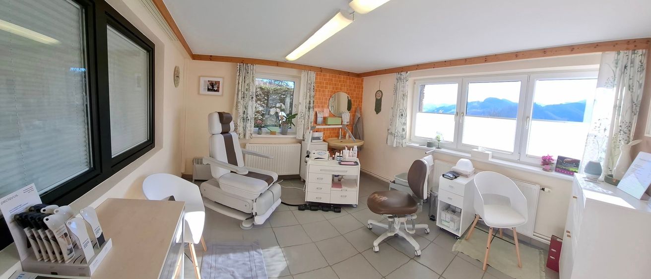 Ein gut beleuchteter Raum mit gefliestem Boden. Es gibt einen weißen Stuhl, ein Waschbecken, einen Heizkörper und ein Fenster. Auf dem Regal befinden sich auch einige Gegenstände. An der Wand befindet sich auch ein Bilderrahmen.