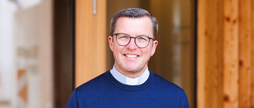 Bild enthält, Face, Head, Person, Smile, Adult, Male, Man, Glasses, Sweater, Priest