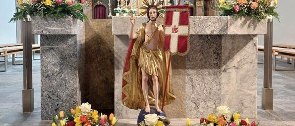 Ein Bild eines dekorierten Altars mit einer goldenen Statue eines Heiligen und einer Flagge. Eine Veranstaltungsankündigung für Ostersonntag, 5. April 2026, um 10:30 Uhr in der Stadtpfarrkirche Trofaiach. Es beinhaltet einen Chor und Solisten.