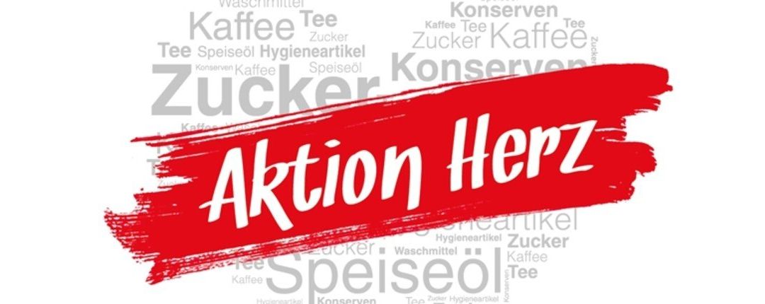 Ein roter Banner mit weißem Text, der 'Aktion Herz' lautet. Darunter sind verschiedene Wörter wie 'Kaffee', 'Tee', 'Zucker', 'Konserven', 'Hygieneartikel' und 'Speisenöl' in verschiedenen Größen und Ausrichtungen verstreut.