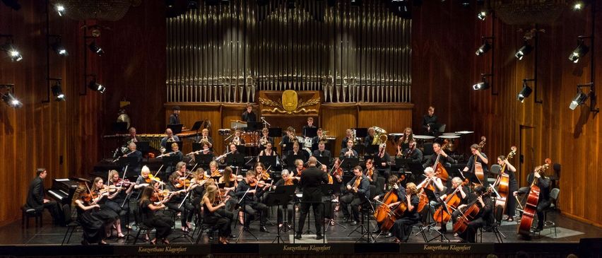 Bild enthält, Indoors, Group Performance, Person, Music, Musical Instrument, Musician, Performer, Orchestra, Music Band, Concert