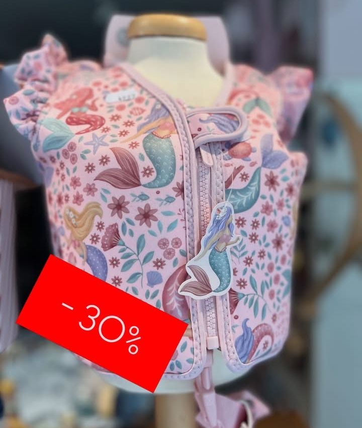 Ein rosafarbenes, meerjungfrauen-thematisches Rettungsschwimmweste mit Reißverschluss und einem 30% Rabatt-Schild an einer Puppe.