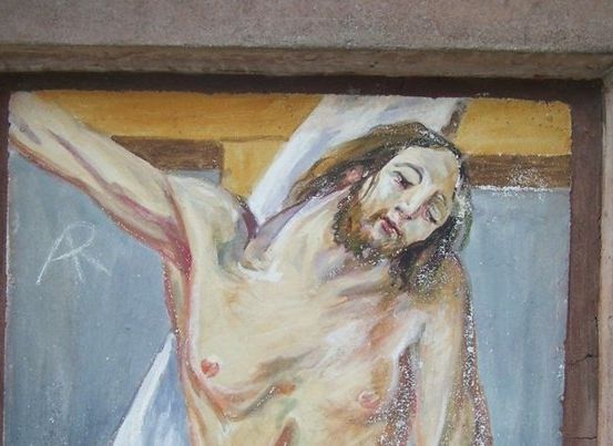 Ein Gemälde von Jesus Christus am Kreuz, mit einem ruhigen Gesichtsausdruck, in einem weißen Tuch gekleidet und in einem Holzrahmen.