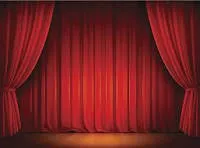 Eine leere Bühne mit roten Vorhängen wird von einem Scheinwerfer beleuchtet und ist bereit für eine Aufführung.