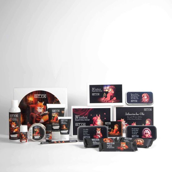 Eine Auswahl an winterlichen Schönheitsprodukten von STYX. Beinhaltet Artikel wie Cremes, Öle und Seifen, alle in festlichen Schachteln verpackt. Die Produkte sind vor einem weißen Hintergrund platziert und zeigen ihre festlichen Designs.