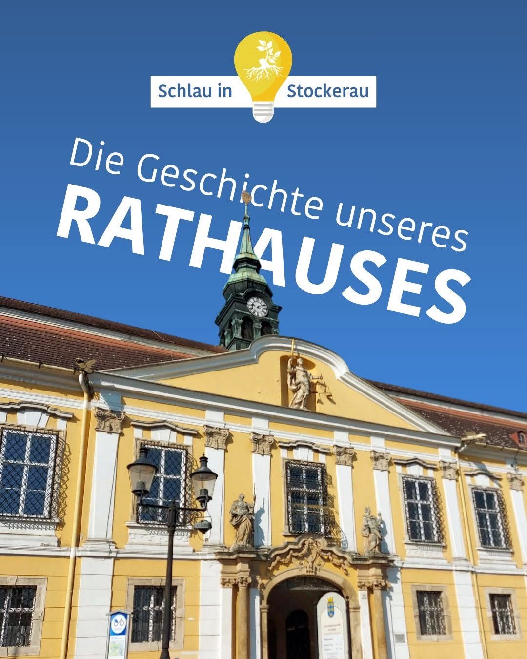 Ein gelbes Gebäude mit Statuen und einem Turm mit einer Uhr darauf. Das Gebäude ist von Straßenlaternen umgeben und hat einen blauen Himmel als Hintergrund.