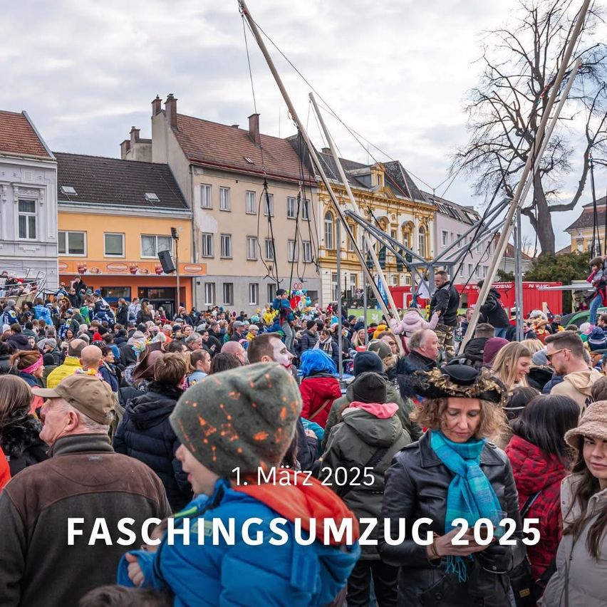 Eine Menschenmenge versammelt sich am 1. März 2025 auf dem Marktplatz für den Faschingsumzug 2025. Im Hintergrund sind Gebäude, Straßenlaternen und Bäume zu sehen. Viele Menschen tragen Mützen und Schals.