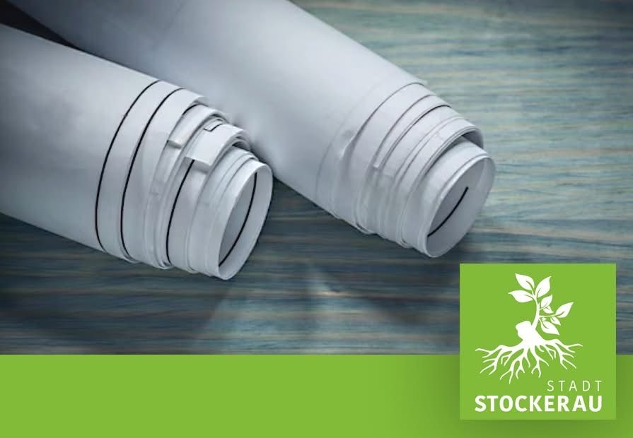 Zwei aufgerollte weiße Papiere auf einer Holzoberfläche mit einem grünen Logo, das unten 'STOCKER' steht.