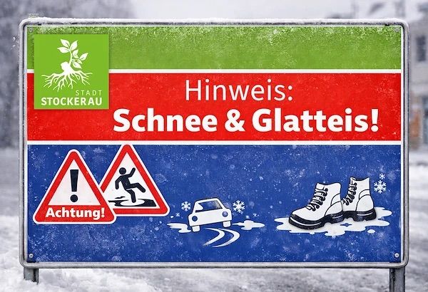 Ein Stadtschild in Stockerau warnt vor Schnee und Eis. Es zeigt eine Person, die ausrutscht, und ein Auto, das ins Rutschen kommt, zusammen mit einem Warnsymbol.