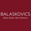 Ein roter Hintergrund mit weißem Text, der 'BALASCOVICS Meine Mode. Mein Moment.' in einer fetten, serifenlosen Schrift liest. Der Text ist zentriert und scheint ein Markenslogan zu sein.
