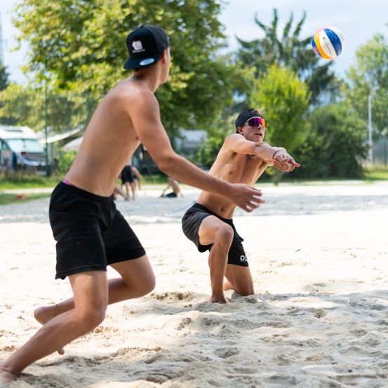 Bild enthält, Shorts, Sphere, Back, Person, People, Volleyball (Ball), Hat, Baseball Cap, Cap, Car