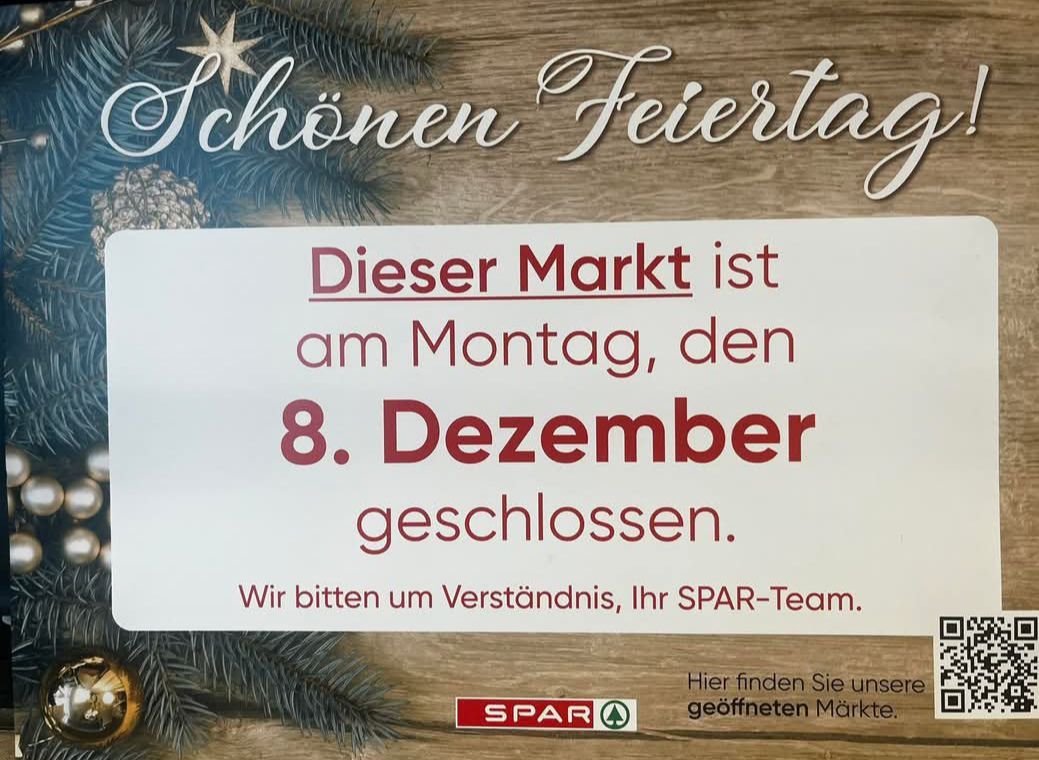 Ein weißes Schild auf einem hölzernen Hintergrund zeigt den Text 'Dieser Markt ist am Montag, den 8. Dezember geschlossen. Wir bitten um Verständnis, Ihr SPAR-Team.' Darunter steht in kleinerem Text 'Hier finden Sie unsere geöffneten Märkte.' Oben sind grüne Tannenzweige und ein Stern.