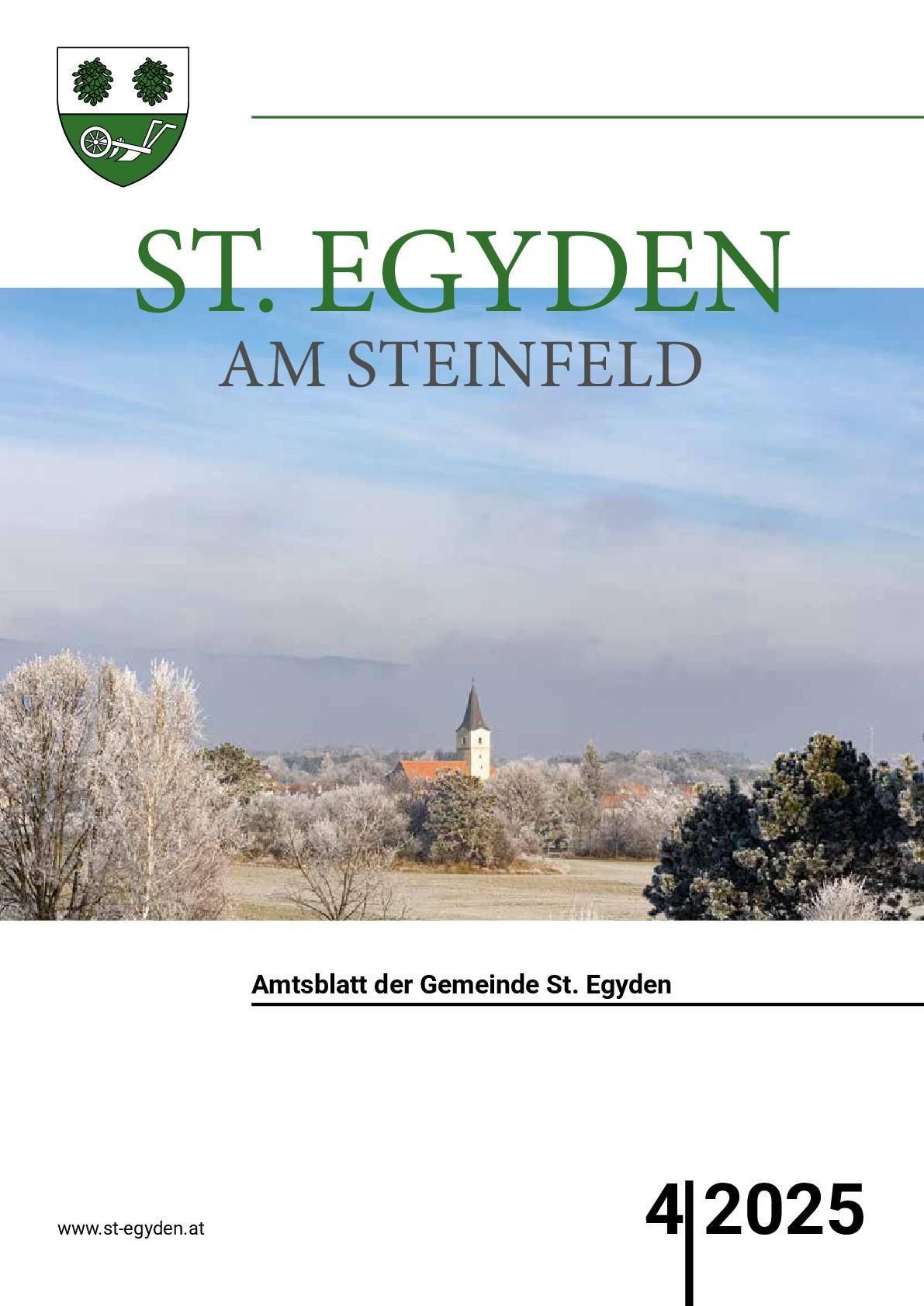 Eine Winterlandschaft zeigt St. Egyden am Steinfeld mit einer Kirche und einem frostbedeckten Feld. Der Himmel ist klar mit einigen Wolken.