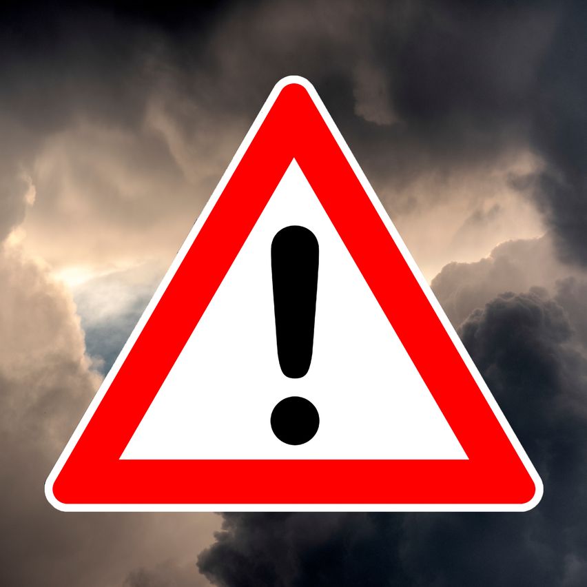 Ein rotes dreieckiges Warnzeichen mit Ausrufezeichen erscheint vor einem Hintergrund eines stürmischen Himmels.