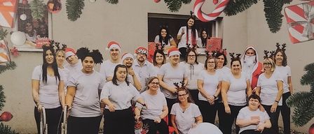 Poster for the opening of a workshop named Veronika with a group of people in Santa hats and holding gifts. The event is on Friday, November 14, 2025, starting at 5 PM.