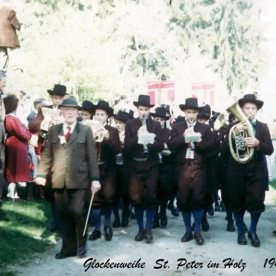 Eine Gruppe von Männern in traditioneller Kleidung spielt Musikinstrumente bei einem Umzug im Jahr 1961.