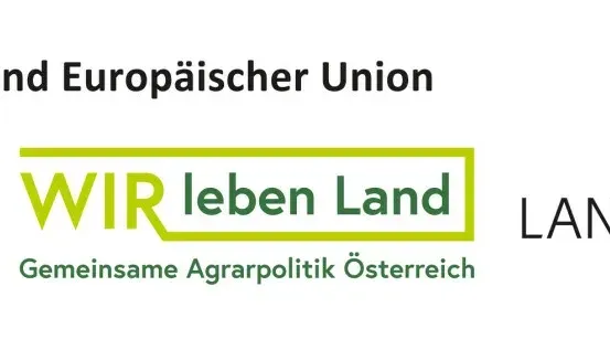 Ein weißer Banner mit grünem Text, der 'Wir leben Land' und gelbem Text, der 'LAND' lautet. Darunter befindet sich ein kleinerer grüner Text, der 'Gemeinsame Agrarpolitik Osterreich' lautet. Über dem Banner steht schwarzer Text, der 'land und Europaischer Union' lautet.