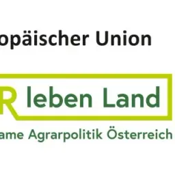 Ein weißer Banner mit grünem Text, der 'Wir leben Land' und gelbem Text, der 'LAND' lautet. Darunter befindet sich ein kleinerer grüner Text, der 'Gemeinsame Agrarpolitik Osterreich' lautet. Über dem Banner steht schwarzer Text, der 'land und Europaischer Union' lautet.