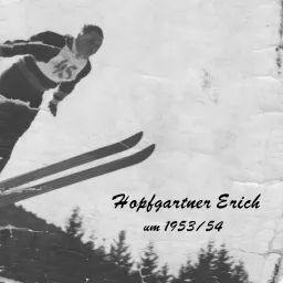Ein Skifahrer namens Erich Hopfgartner springt in der Luft in einer verschneiten Landschaft, aufgenommen um 1953/54.