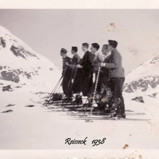 Ein Schwarz-Weiß-Foto aus dem Jahr 1938 zeigt fünf Männer, die in einem verschneiten Berggebiet auf Skiern stehen und Skistöcke halten. Das Foto trägt die Bezeichnung 'Reisseck 1938'.