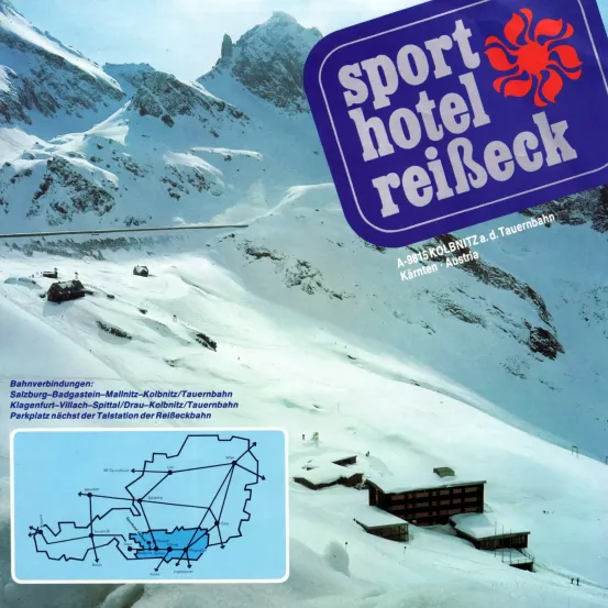 Ein Skigebiet mit schneebedeckten Gebäuden. Das Schild zeigt Sport Hotel Reibeck, mit Logo und weiterer Text. Es gibt Bahngleise und eine Karte, die das Gebiet darstellt.