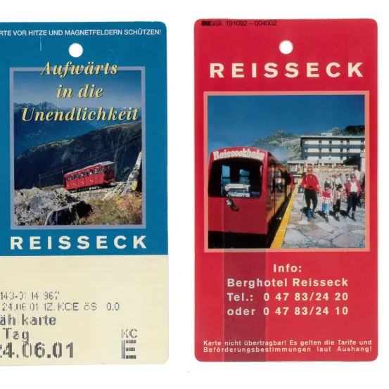 Zwei Fahrkarten für die Reisseckbahn Bergbahn, mit einem roten Zug auf der Strecke, einem Hotel und Kontaktinformationen für das Berghotel Reisseck.