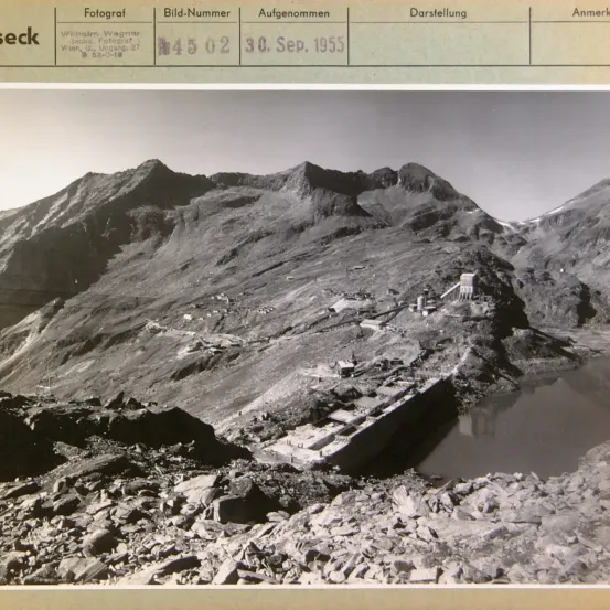 Eine Schwarz-Weiß-Fotografie einer Gebirgsregion mit einem Wasserzeichen vom '30. Sep. 1955'. Das Bild zeigt eine felsige Landschaft mit einem kleinen Gewässer im Vordergrund.