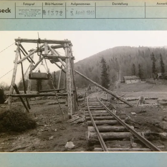 Ein Schwarz-Weiß-Foto vom 5. April 1949 zeigt eine Eisenbahnschiene mit hölzernen Schwellen und einer hölzernen Struktur im Hintergrund.